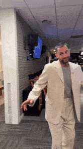 a man in a suit is standing in a hallway