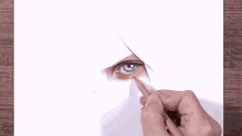 a person is drawing a leaf with a pencil on a piece of white paper .