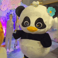a panda mascot with a flower in its hair