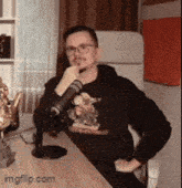 a man is sitting at a desk with a microphone .