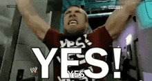 a man is raising his arms in the air and saying yes .