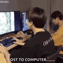 a man is playing a video game on a computer while another man watches .