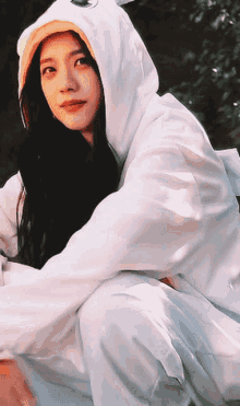 a woman is wearing a white hoodie with a yellow hat on her head