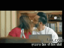a man and a woman kissing in front of a laptop