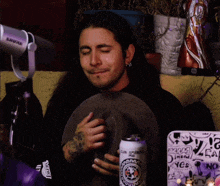 a man is crying while holding a can of beer that says club apocalypse