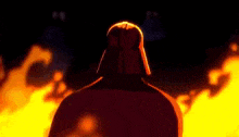 darth vader is standing in front of a large fire in the dark .