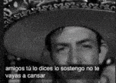 a black and white photo of a man wearing a sombrero and a mexican hat .