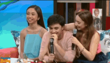 a group of people sitting on a couch with a microphone in front of them