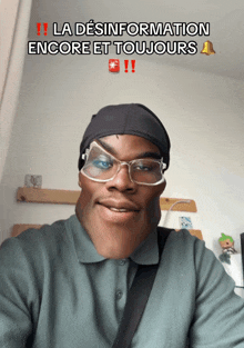 a man wearing glasses and a beanie with the words la desinformation encore et toujours