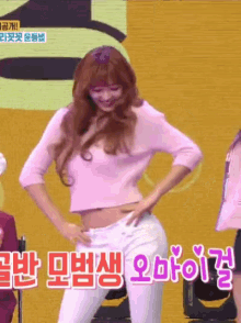 a woman in a pink crop top and white pants is dancing on stage
