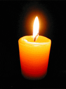 a candle is lit up in the dark with a single flame