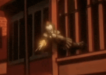 a man is holding a gun in his hand while standing on a balcony .