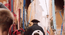 a man in a costume is walking down a narrow street