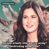 a woman is smiling and saying `` because actually what are you saying ? hardworking means what '' .