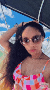 a woman wearing sunglasses and a bikini is being edited by youcam makeup software