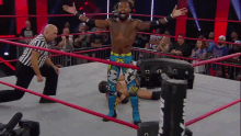 a wrestler with the number 25 on his shorts is standing in the ring