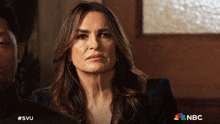 a woman is sitting in front of a sign that says " nbc "