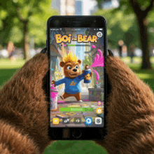 a teddy bear is holding a cell phone with a boy bear game on it