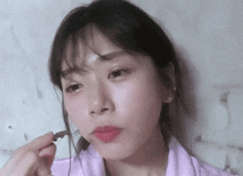 a woman in a pink shirt is eating a piece of food
