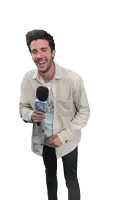 a man laughs while holding a microphone that says fair
