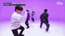 a group of young men are dancing on a purple background in front of a mnet sign .