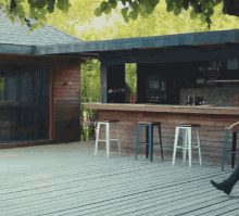 a person sits on a stool in front of a wooden bar