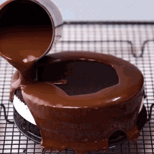 a chocolate cake is being poured with chocolate icing