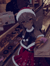 a girl in a santa outfit is holding a donut and a piece of paper that says oyasu on it