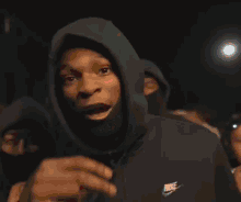 a man in a hoodie holds up a sign that says by a bitch rtp