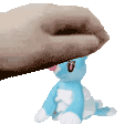a person is petting a blue stuffed animal with their finger .