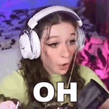 a woman wearing headphones and a microphone is making a funny face .