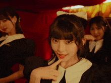 a girl with a cat ear headband is pointing at the camera