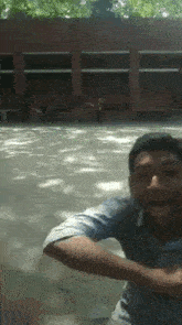 a man is standing in front of a building with his hands in the air .