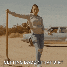 a woman is holding a shovel in the dirt with the words getting daddy that dirt below her