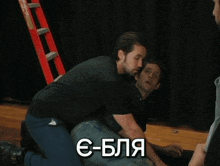 a man kneeling on the floor with e-bla written on the bottom right