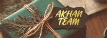 a gift wrapped in green paper with a label that says akhan team