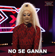 a drag queen says " no se ganan " in front of an x factor logo