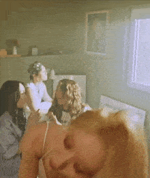 a group of women are sitting in a room and one of them is laying on the floor .