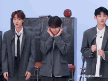 three young men in suits and ties are standing in front of lockers and a basketball ..