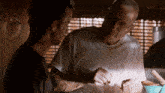 a man in a white shirt talks to another man