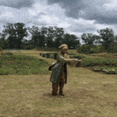 a statue of a woman standing in a field holding a bag