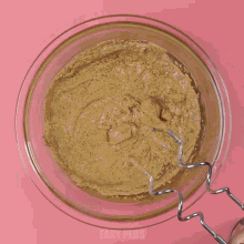 flour is being poured into a bowl of brown batter