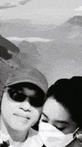 a black and white photo of a man and woman wearing face masks
