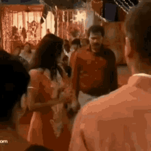 a woman in a red dress is dancing in a crowd of people