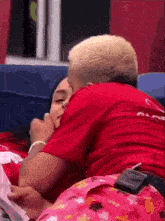 a man in a red shirt is kissing a woman .