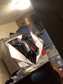 a closet filled with clothes and a cardboard box that says usps on it