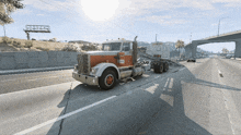 a semi truck is driving down a highway with a billboard in the background