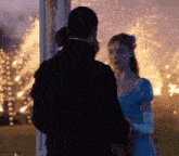 a man and a woman are standing next to each other in front of a burning building .