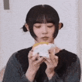 a young woman is eating a sandwich with whipped cream on top .