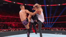 a wrestler is kicking another wrestler in the face during a match .